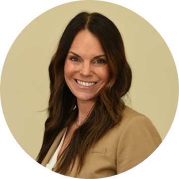 Professional headshot of smiling woman with dark hair wearing tan blazer