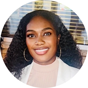 Professional headshot of smiling woman with curly dark hair wearing hoop earrings