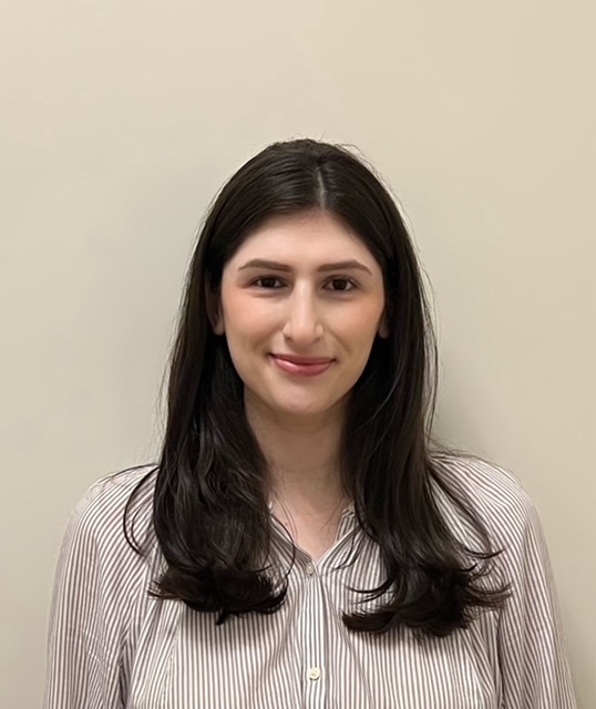 Romina Tortoriello, woman with long black hair in striped button-up shirt, professional headshot