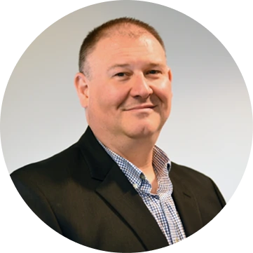 Professional headshot of male team member in dark blazer and checkered shirt