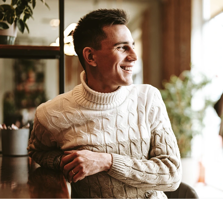 Smiling man in a sweater relaxing at home