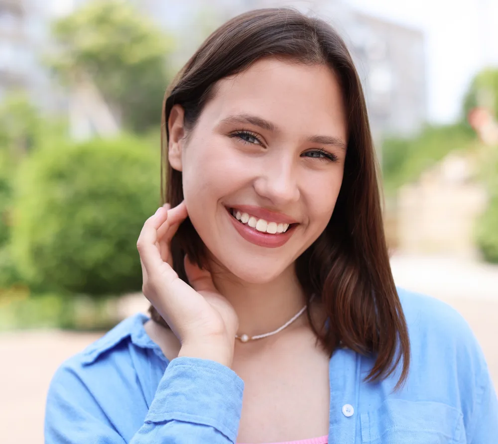 Smiling young woman outdoors in a blue shirt