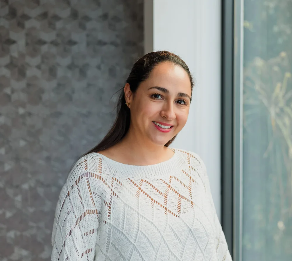 Smiling woman standing by a window