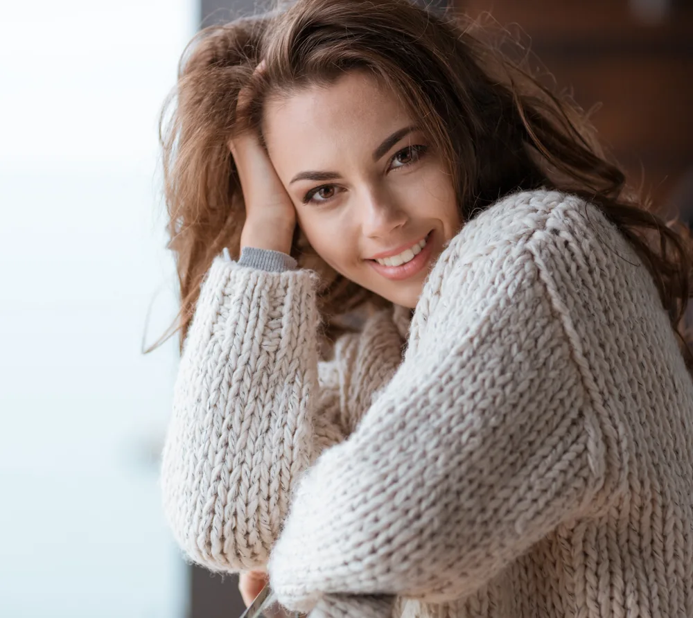 Smiling woman in a cream sweater