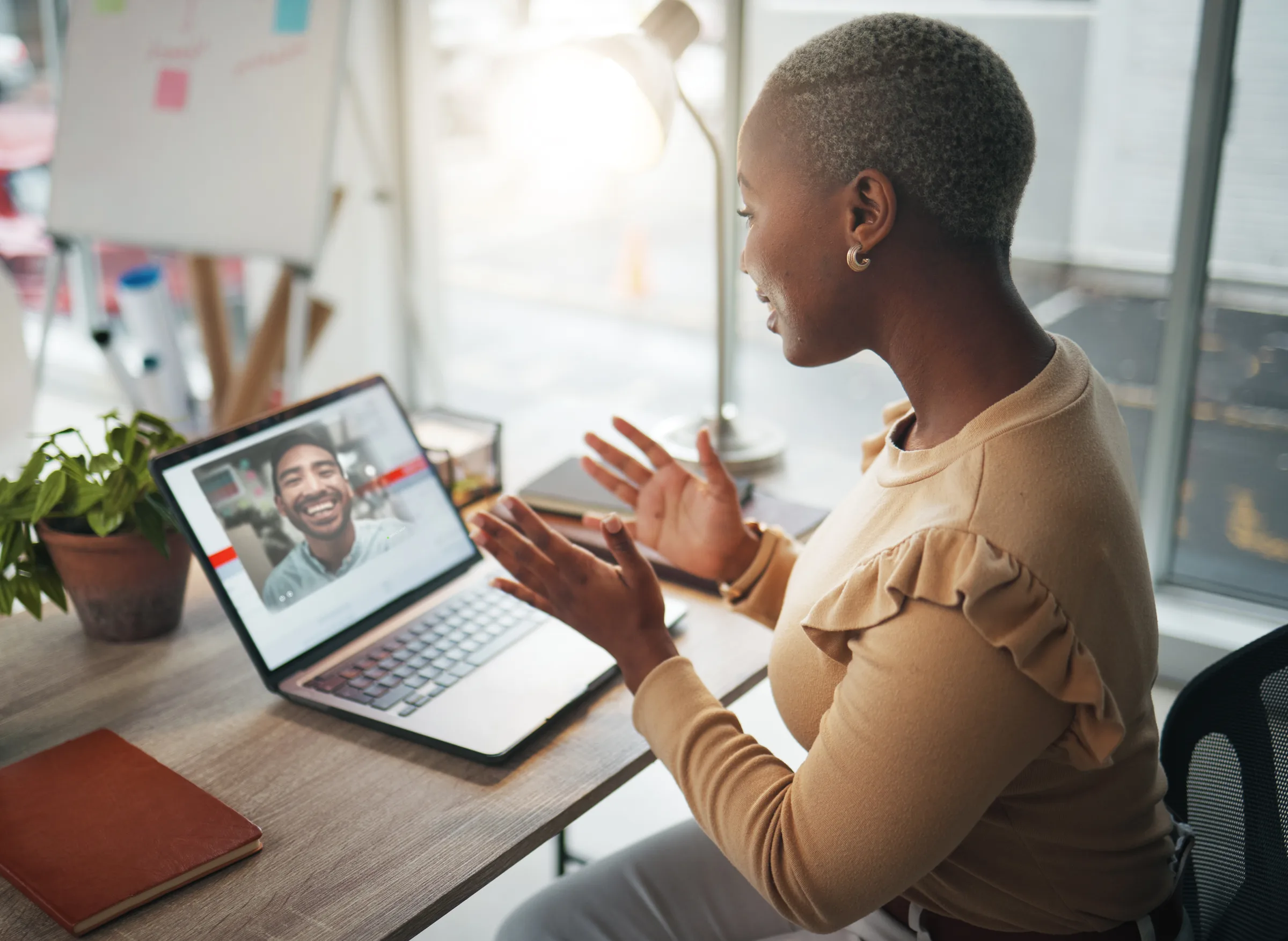 Woman gesturing during a friendly video call at her desk