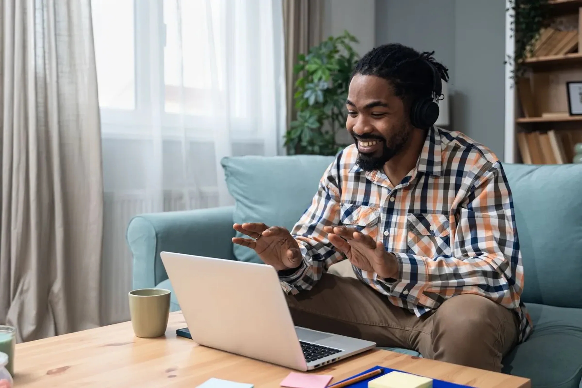 Man with headphones talking during a video visit at home