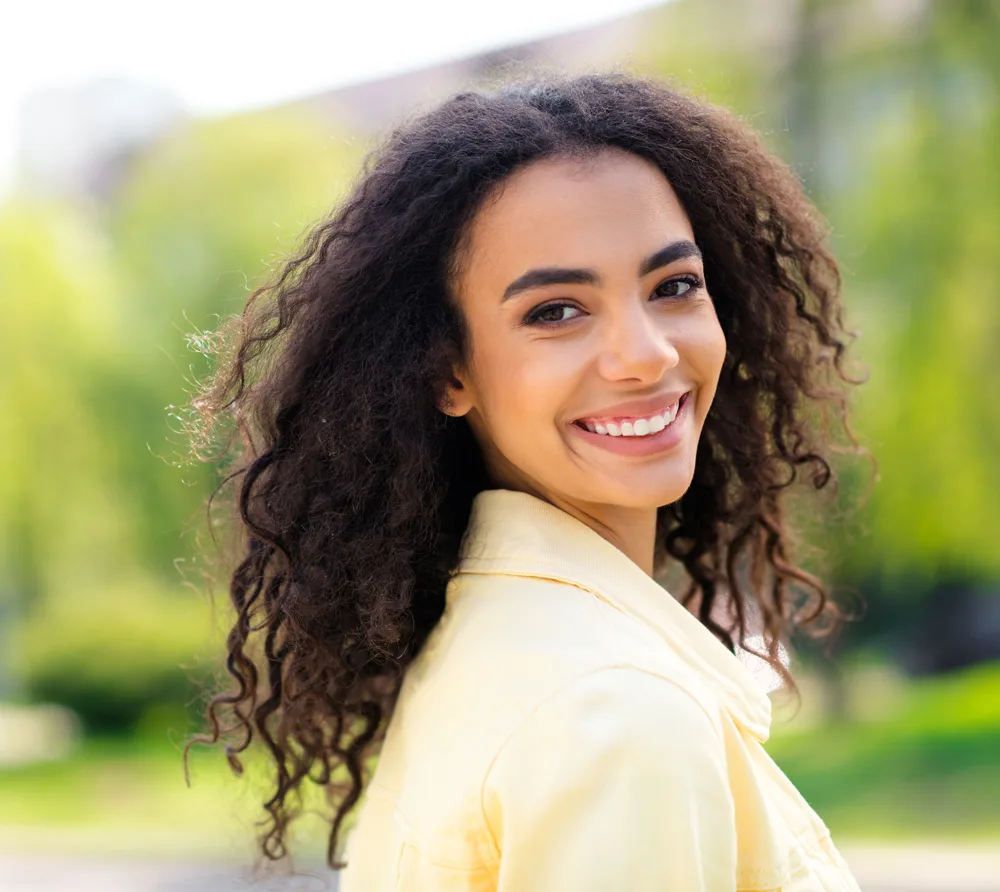 Smiling woman with curly hair outdoors