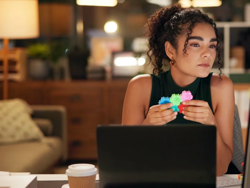 Young woman at her laptop holding a fidget toy