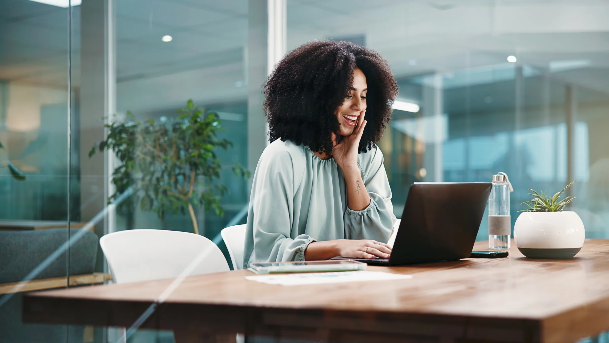 Woman smiling during a video call on her laptop at work