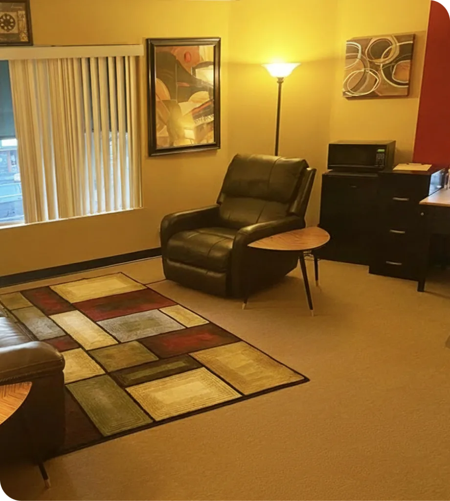 Daybreak Counseling Center waiting room with yellow walls, black leather recliner, geometric area rug, and framed artwork