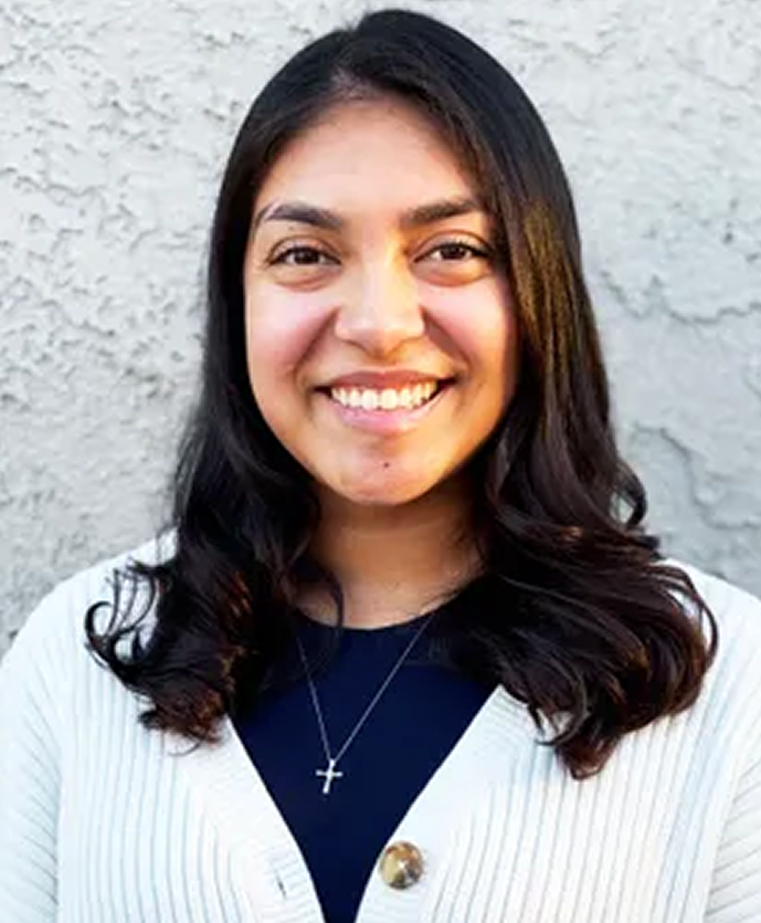 Jocelyn, counselor at Daybreak Counseling Center, smiling at camera wearing white cardigan and cross necklace