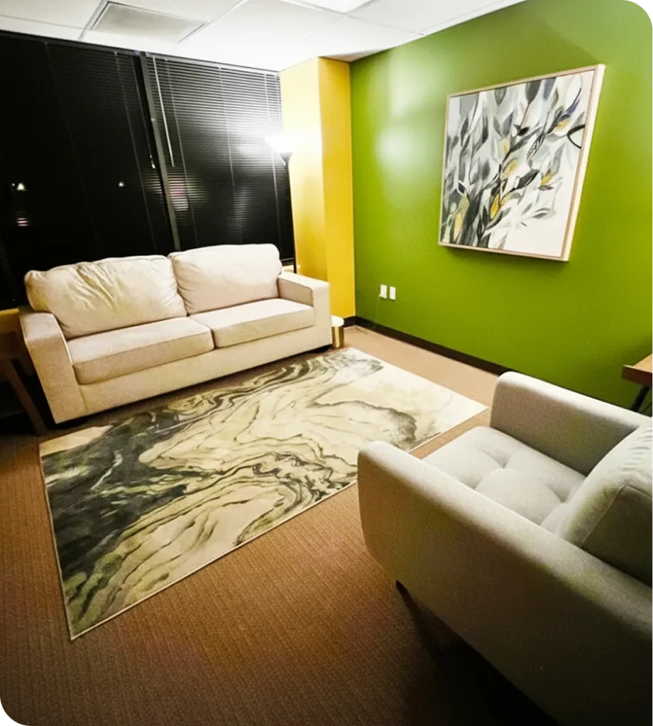 Cerritos counseling office with cream sofa, geometric area rug, green wall, and modern artwork