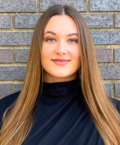 Victoria, counselor at Daybreak Counseling Center, poses for headshot against brick wall