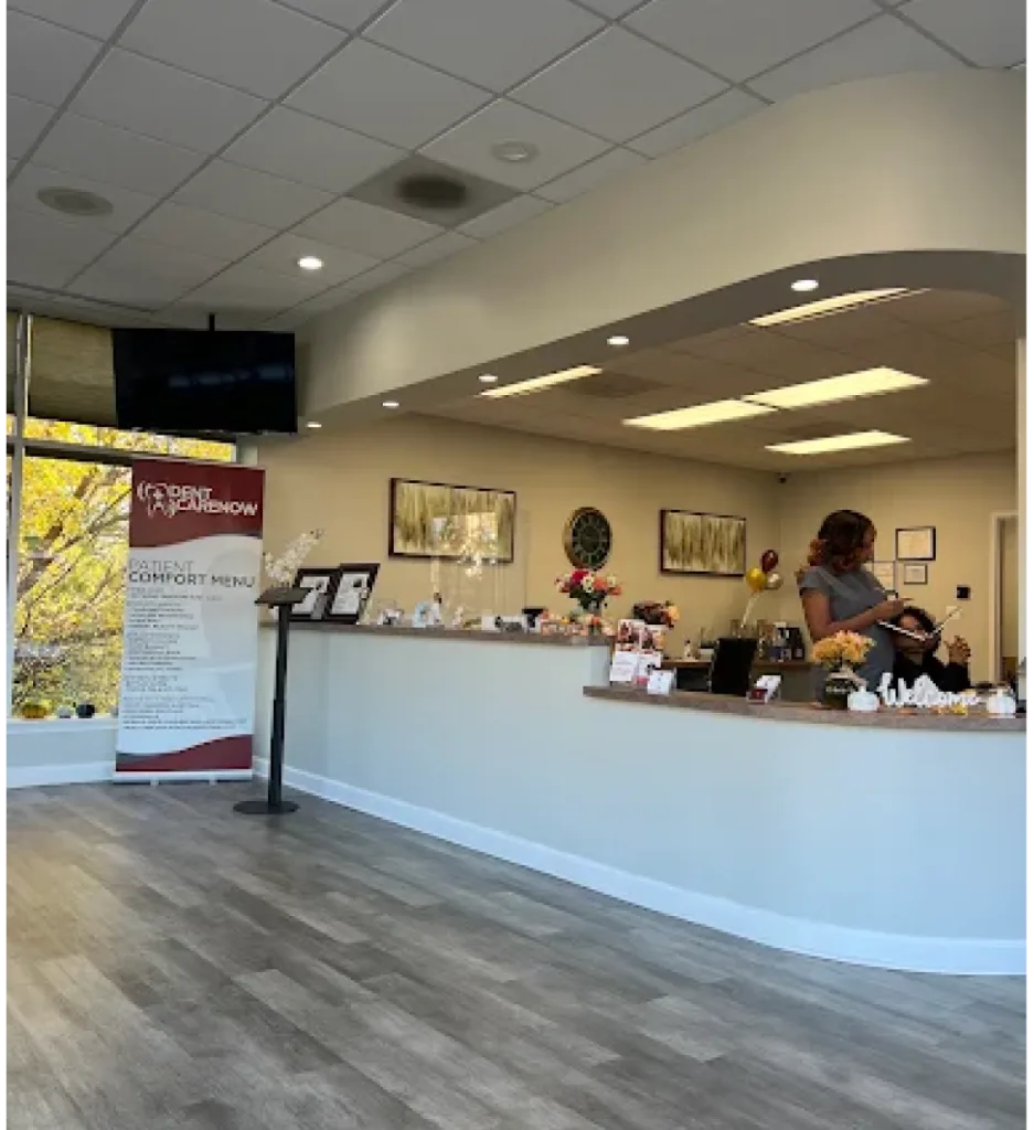 Dent Care Now reception area with front desk staff, signage, and comfortable waiting space