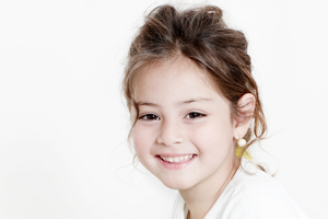 Young girl smiling, displaying healthy teeth