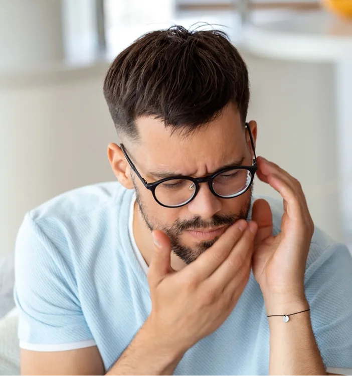 Man holding his cheek in pain, depicting toothache discomfort