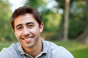Young man smiling outdoors with healthy teeth