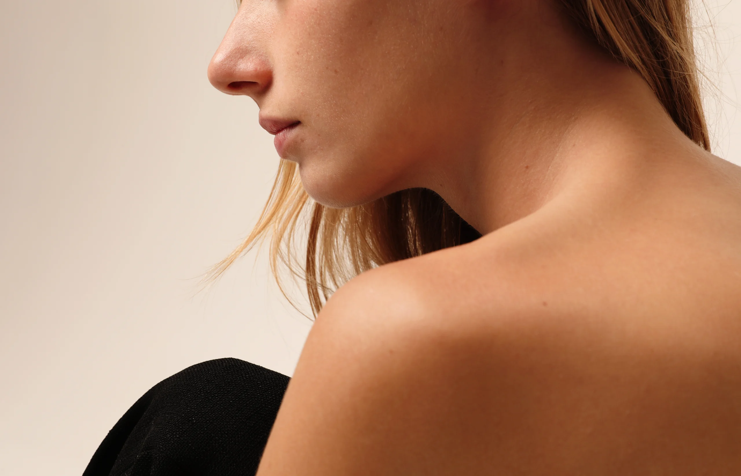 Woman's profile and shoulder showing clear skin after dermatological treatment