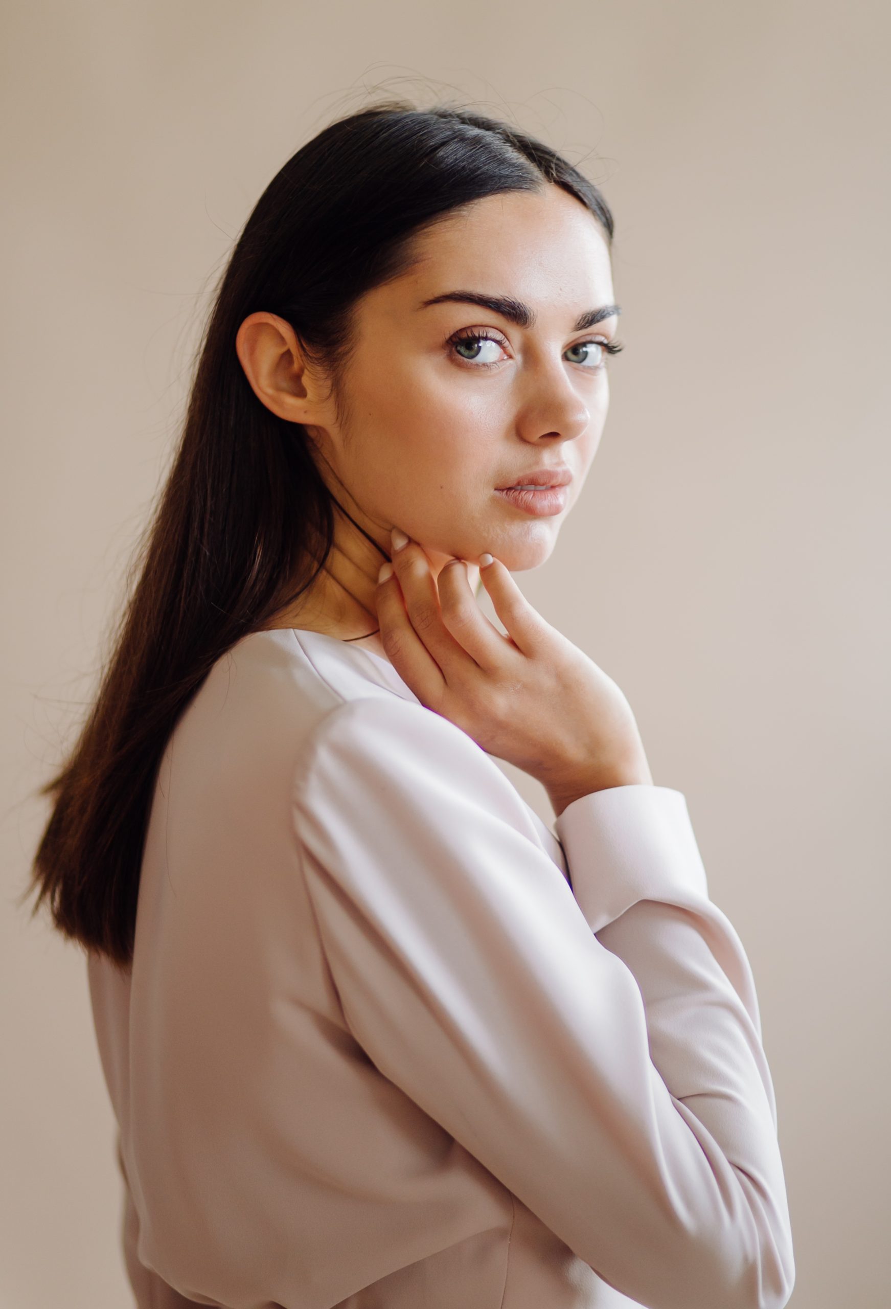 Woman touching her neck and jawline while looking to the side