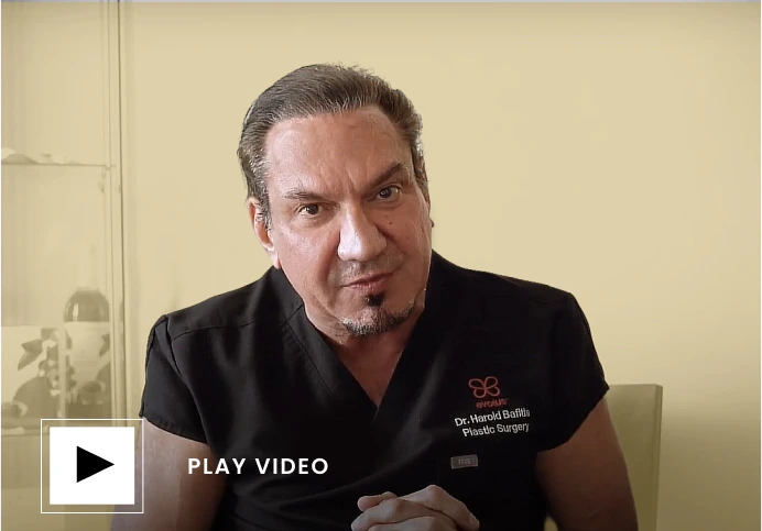 PLAY VIDEO button overlaid on Dr. Harold Bafitis in black scrubs