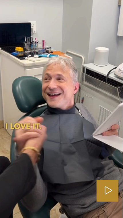Patient smiling in dental chair with text overlay 'I LOVE IT'