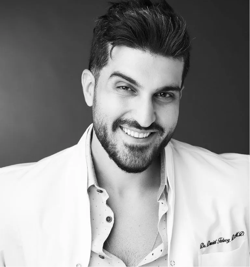 Dr. David Toksoy, dentist, smiling in professional headshot wearing white shirt