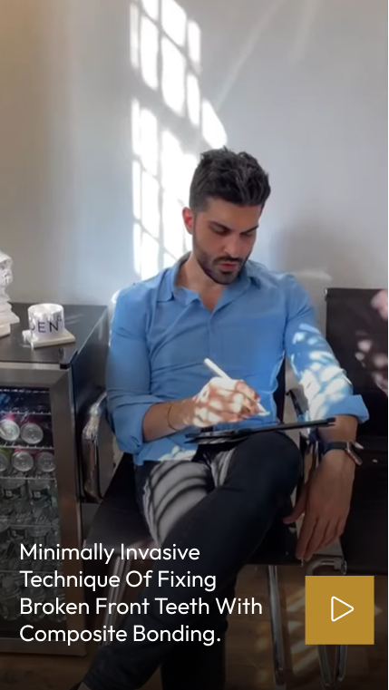 Dentist in blue shirt explaining composite bonding treatment on tablet to patient in bright office with dental equipment visible
