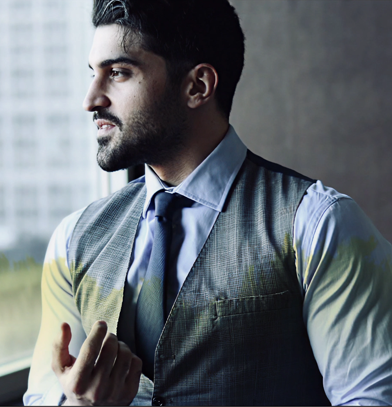 Man in business shirt and tie standing against urban building backdrop