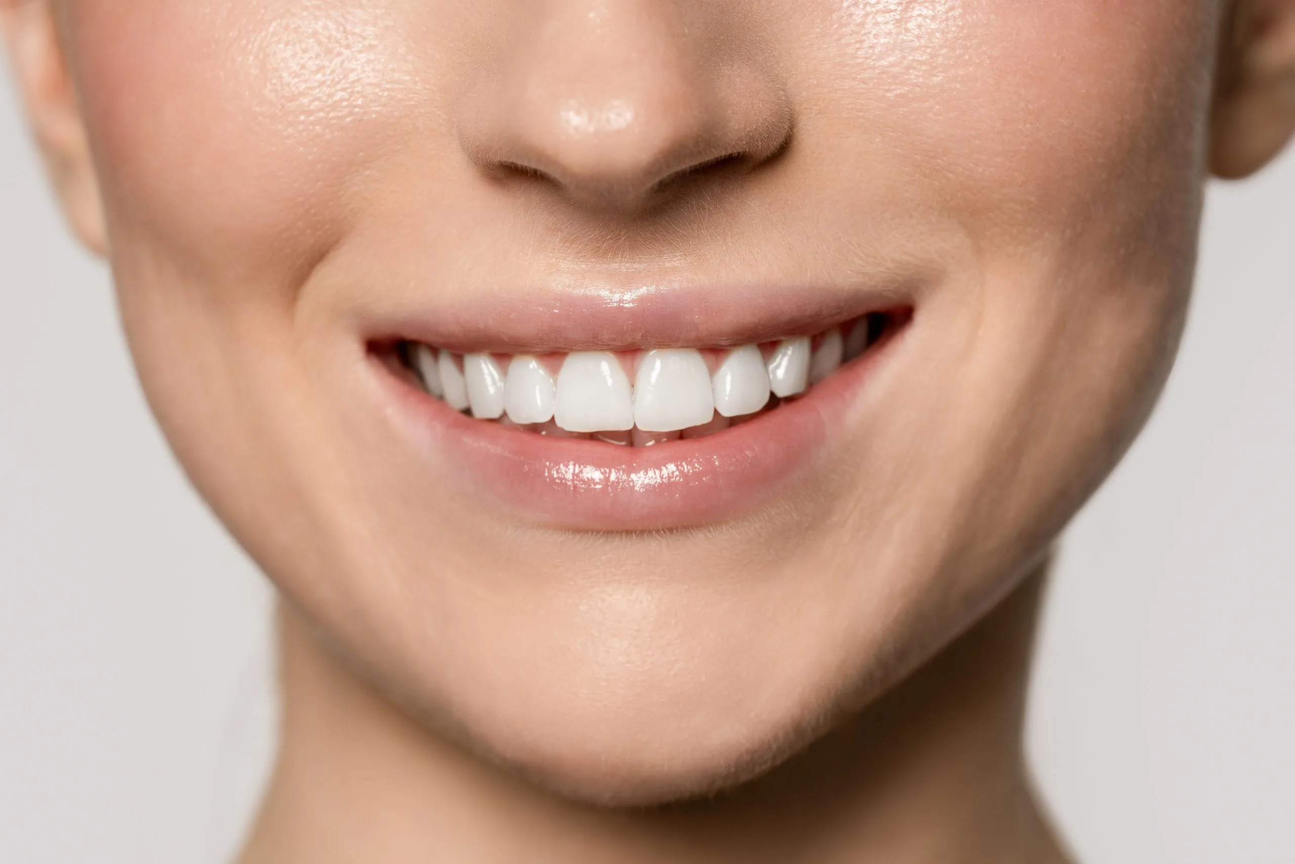 Woman smiling to display bright white teeth in natural light