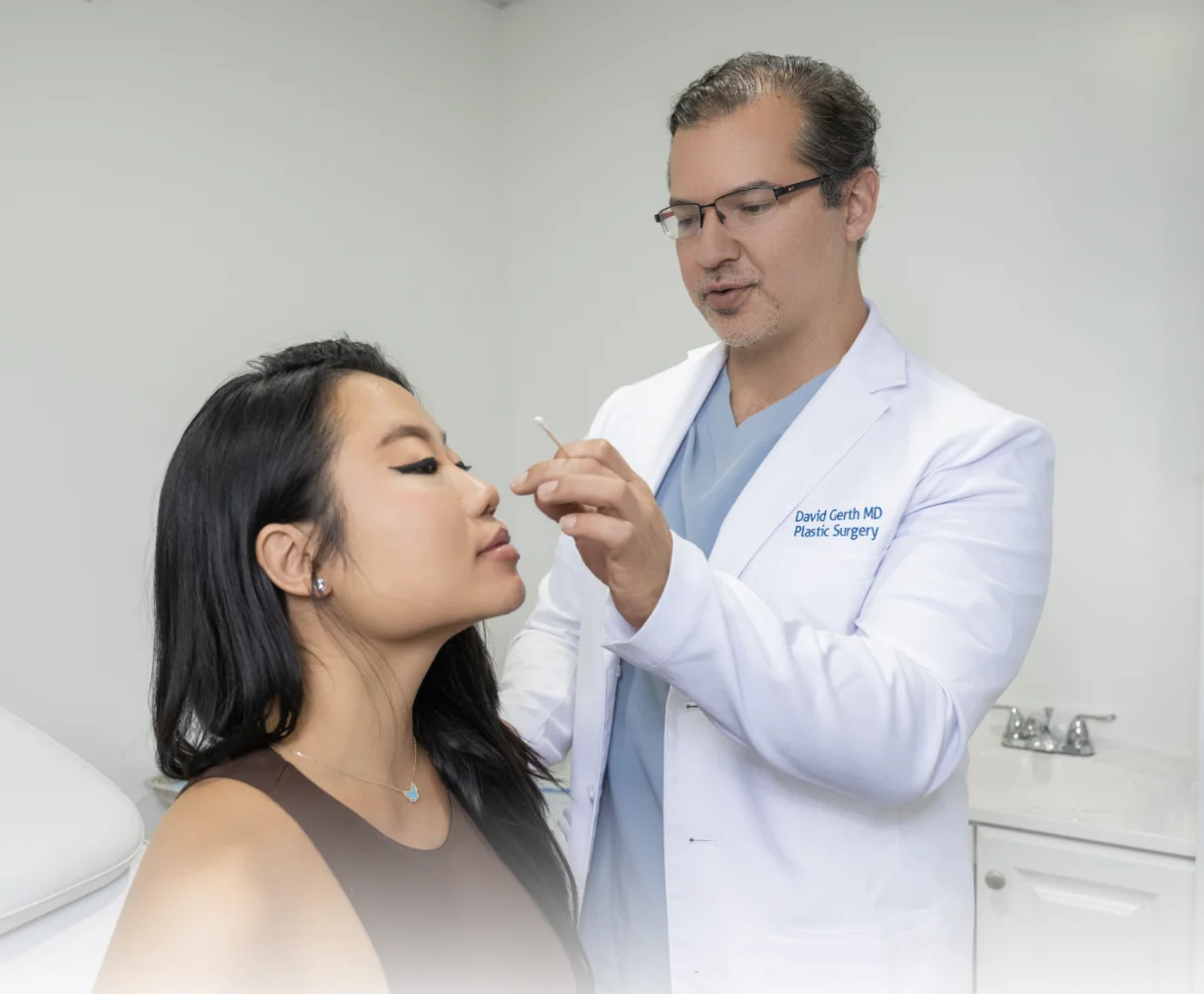 Dr. David Gerth examining patient's nose in consultation during plastic surgery consultation