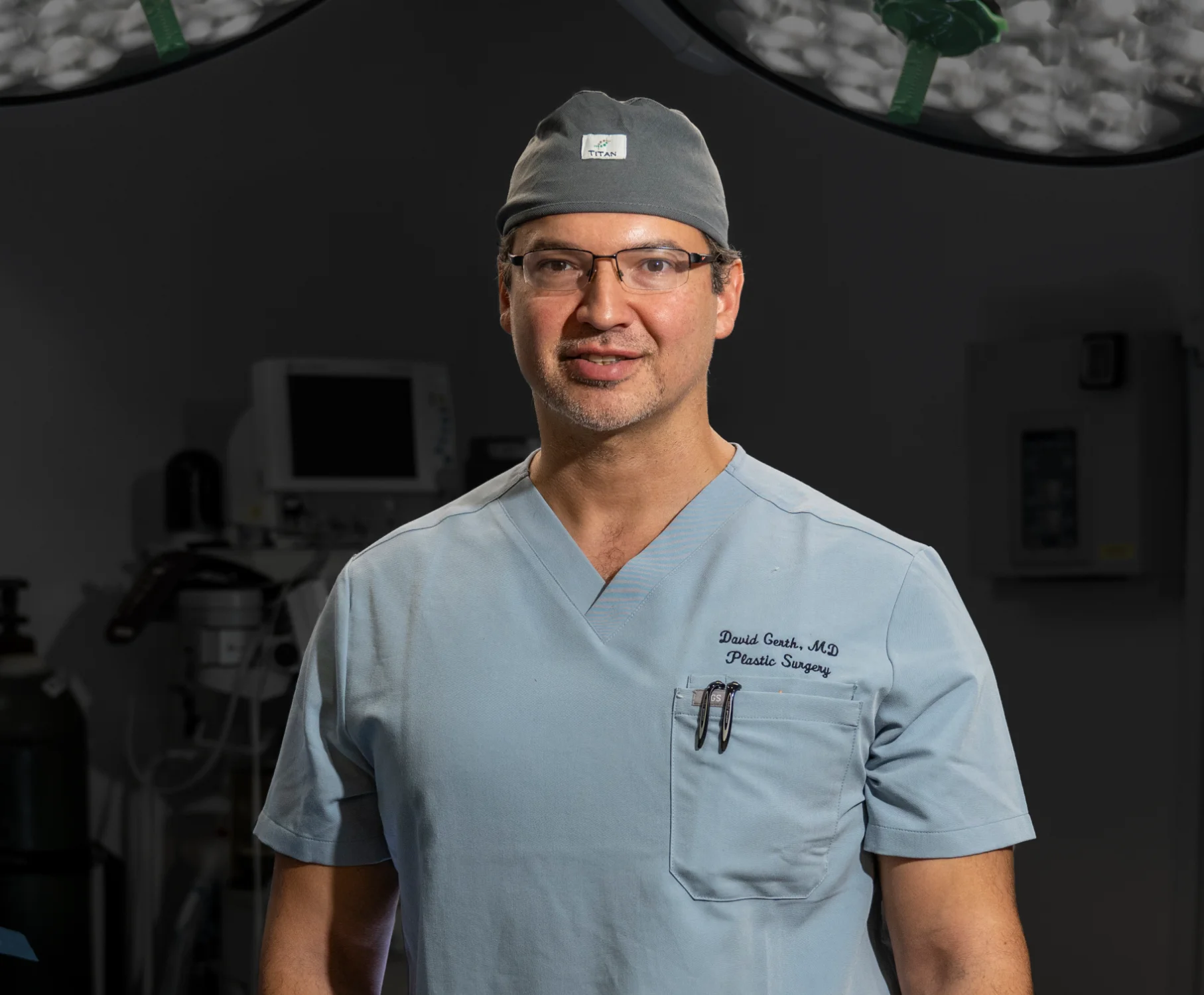 Dr. David Gerth wearing surgical scrubs and cap in operating room