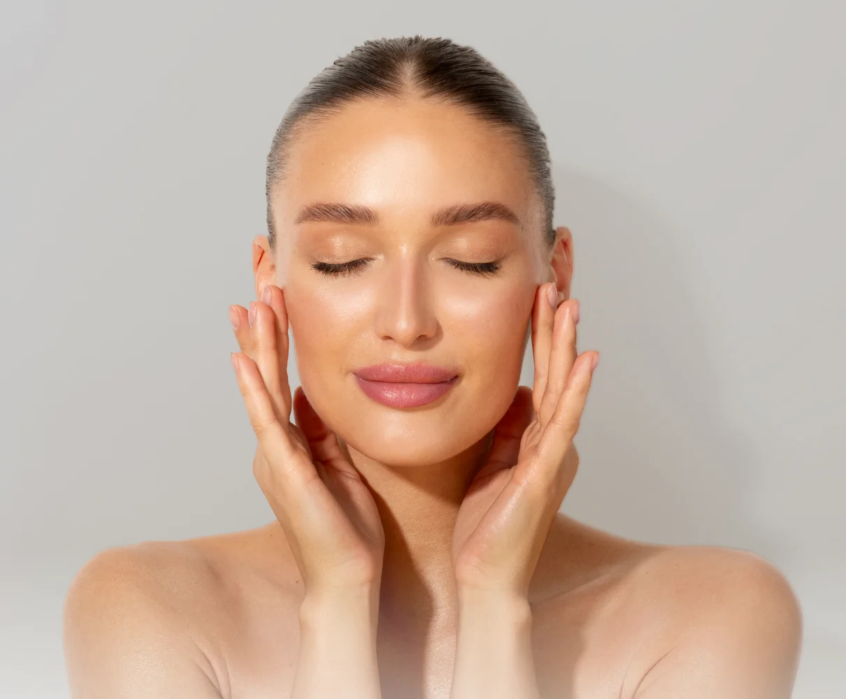 Woman with hands gently framing her face, demonstrating smooth, refreshed skin