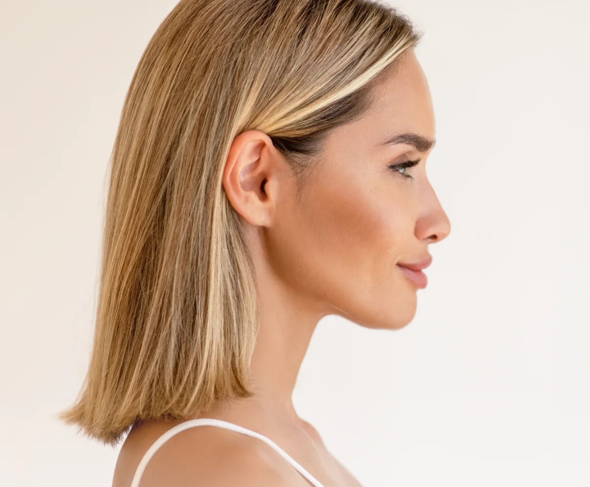 Woman in profile with shoulder-length blonde hair, showing facial contours
