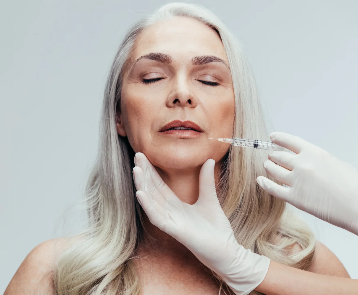 Dr. Gerth administering dermal filler injection to patient's cheek area