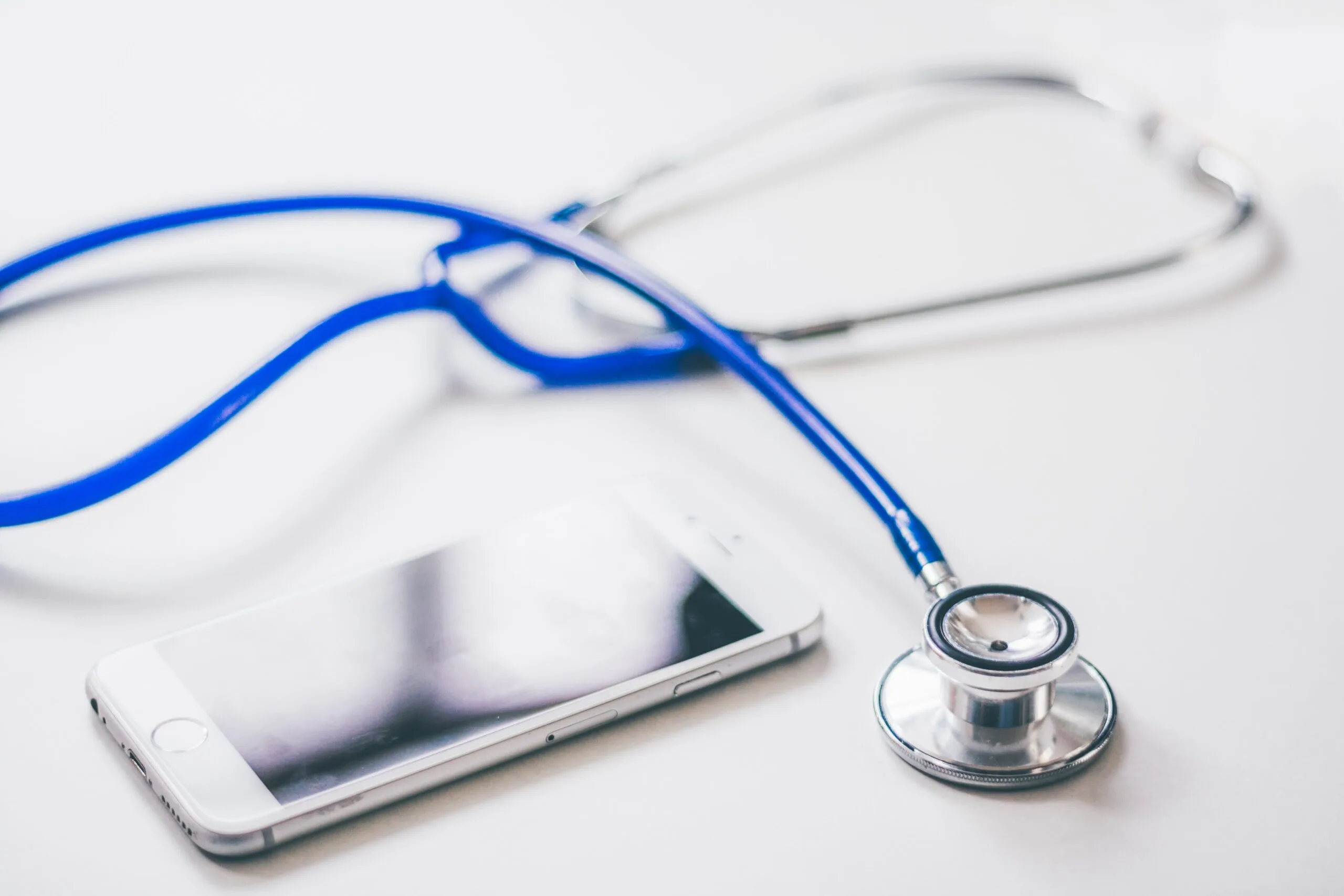 Smartphone and stethoscope on a desk - consulting a plastic surgeon about breast reduction for teens