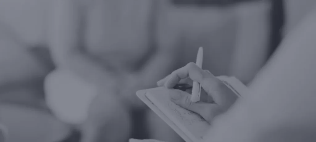 Person's hands holding and examining a clipboard with test materials