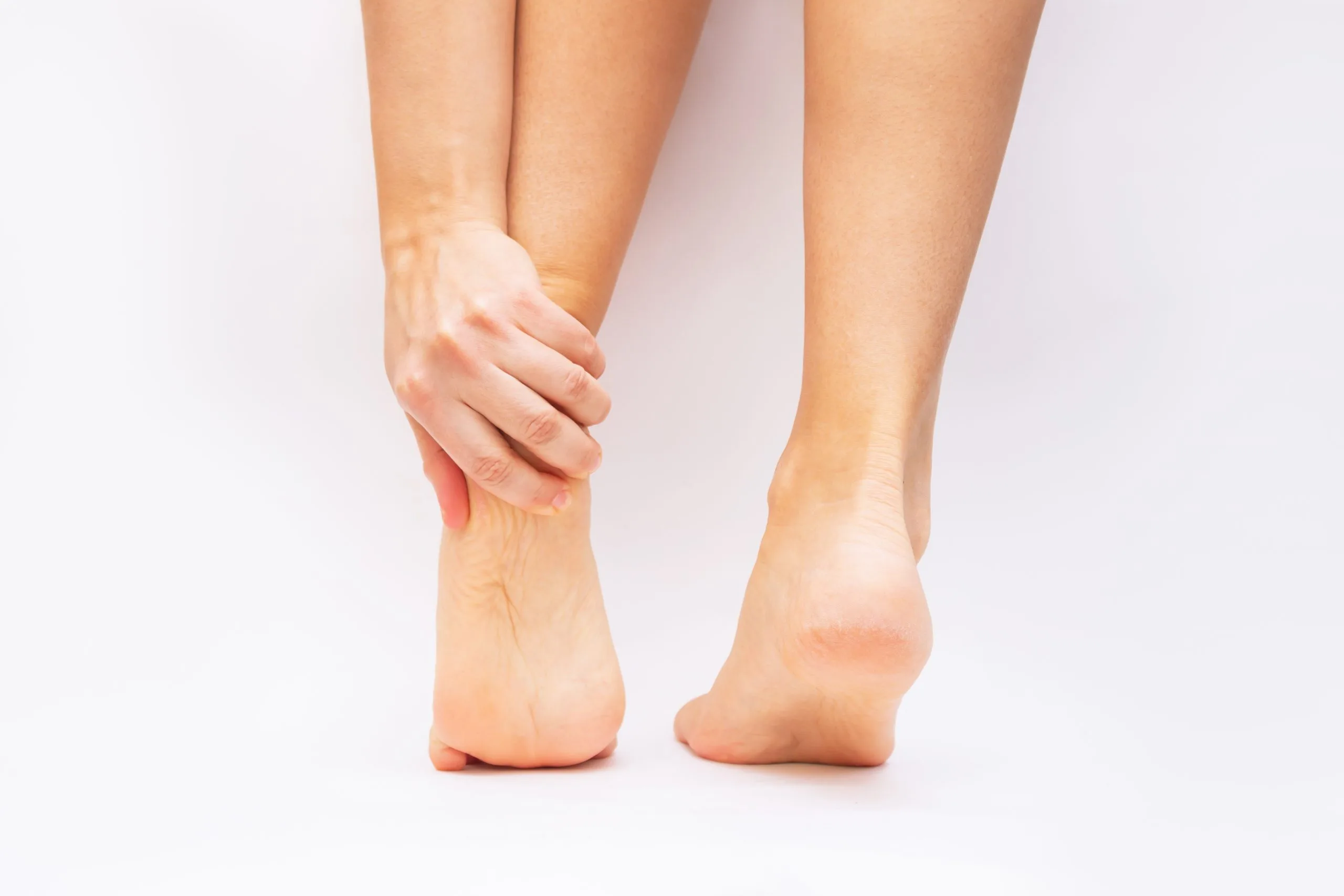 Close-up of a person holding the heel of a bare foot