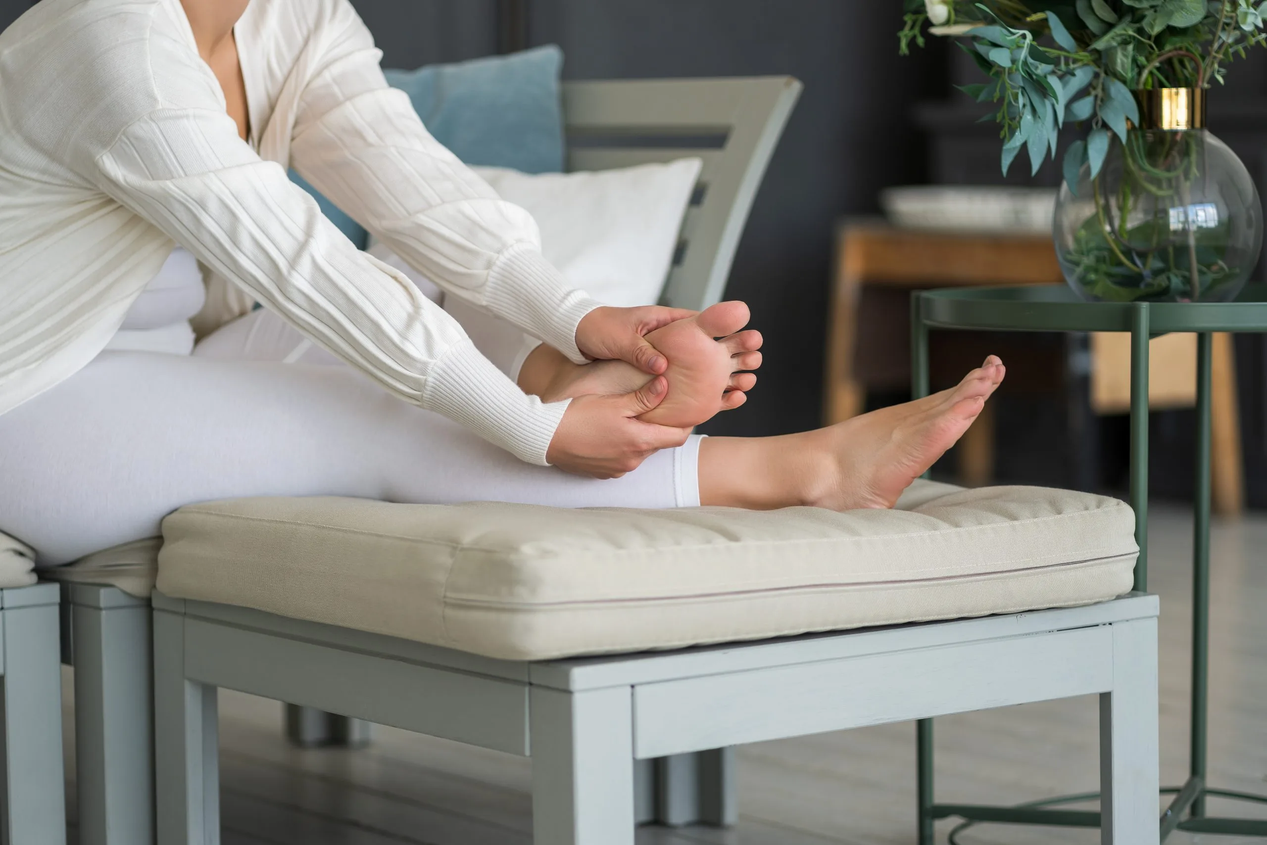 Woman seated holding her bare foot to check it