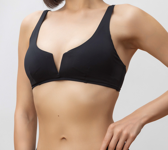 Patient's torso showing post-breast reduction results in black supportive bra