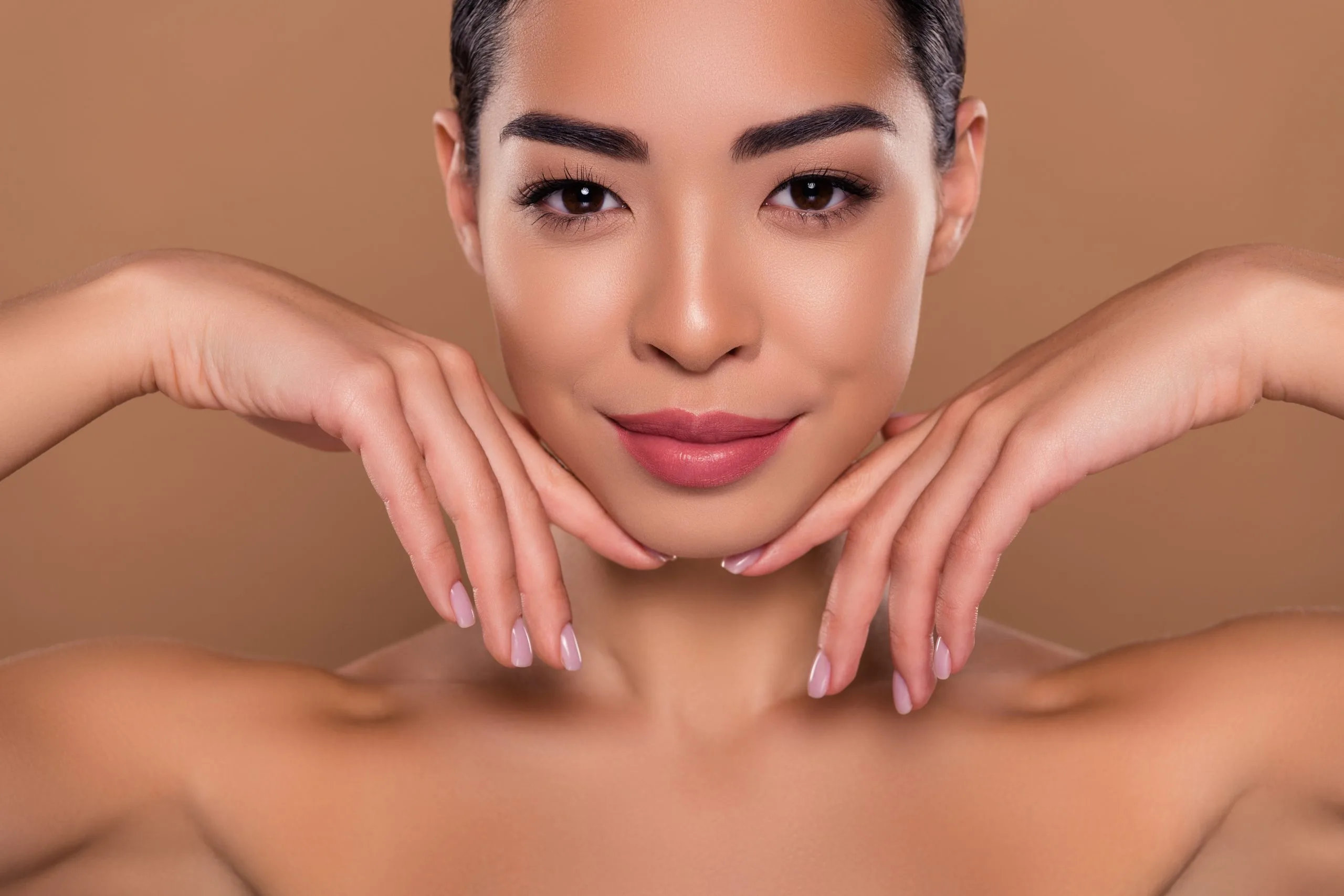 Woman with hands framing her face, displaying facial contours and skin texture