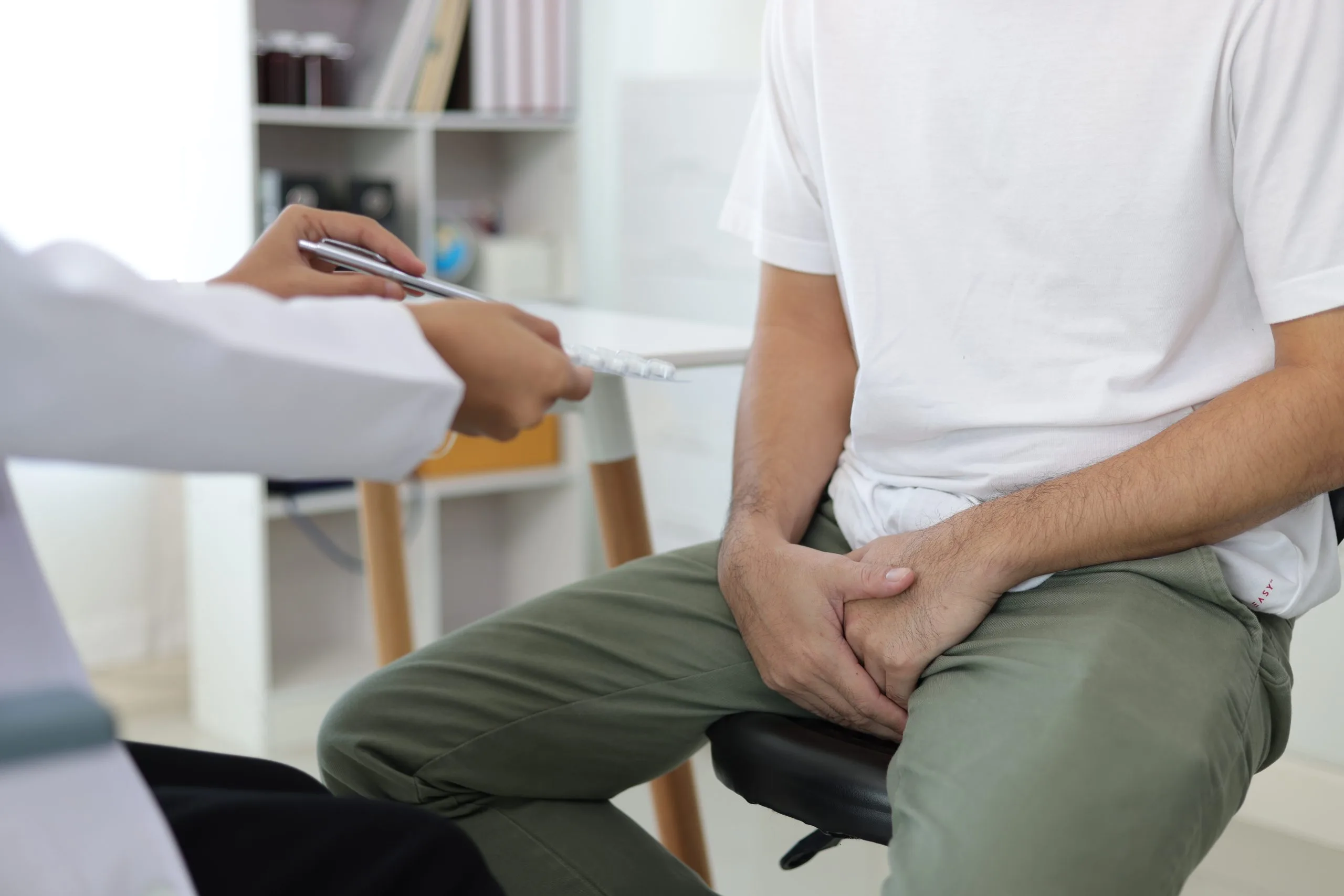 Doctor holding clipboard taking notes during patient consultation in clinic