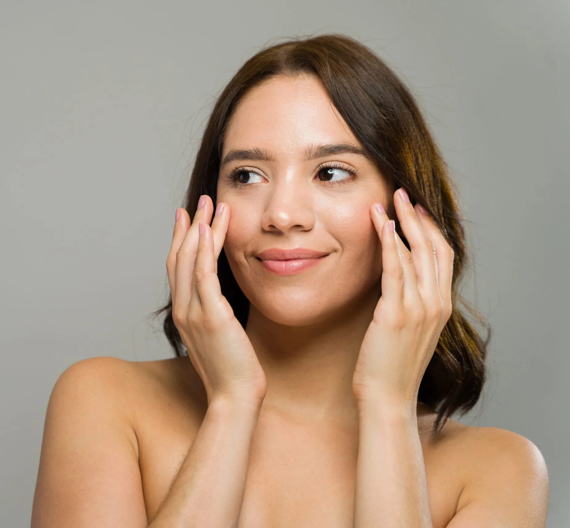 Woman with hands near her face, looking to the side