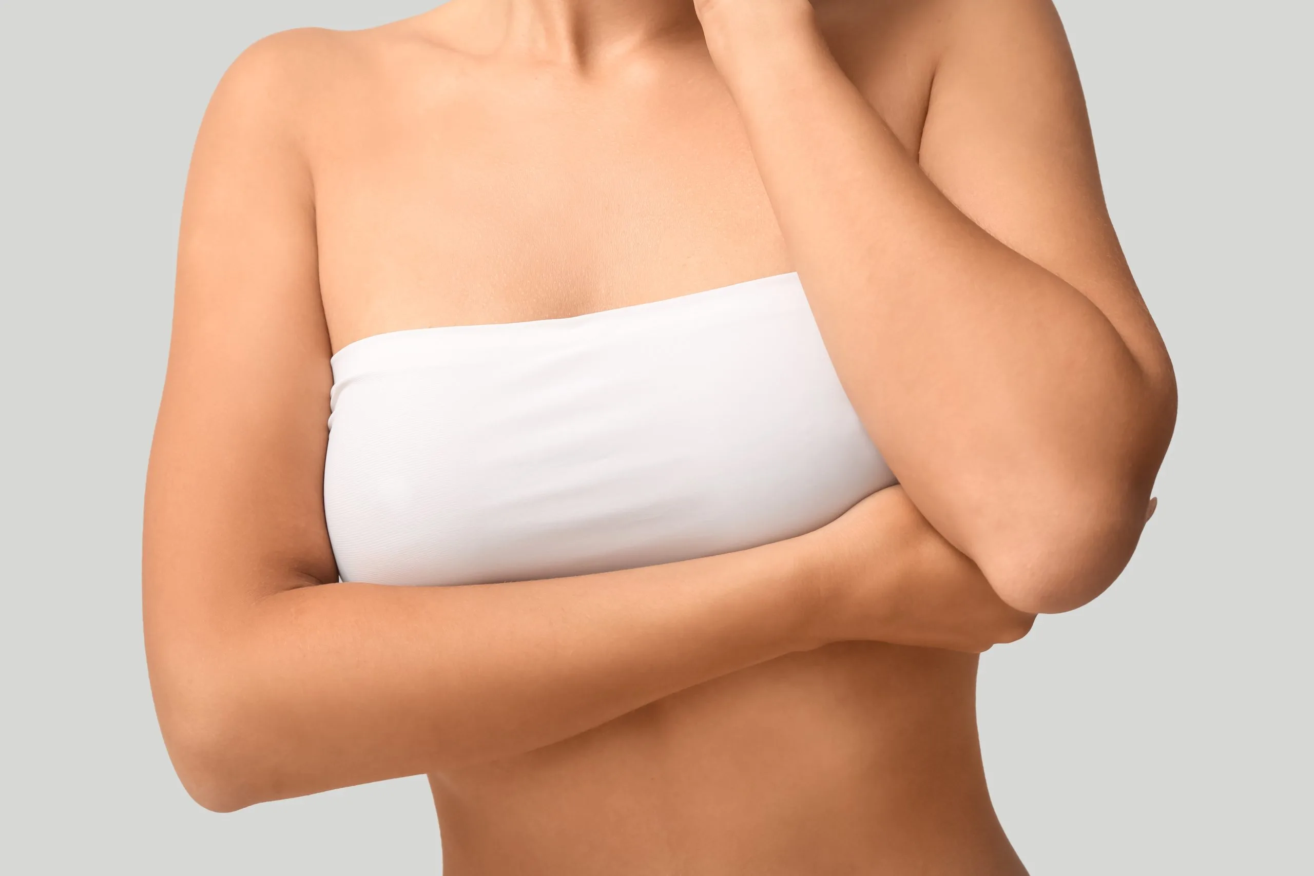 Woman wearing white bandage across torso, arms crossed