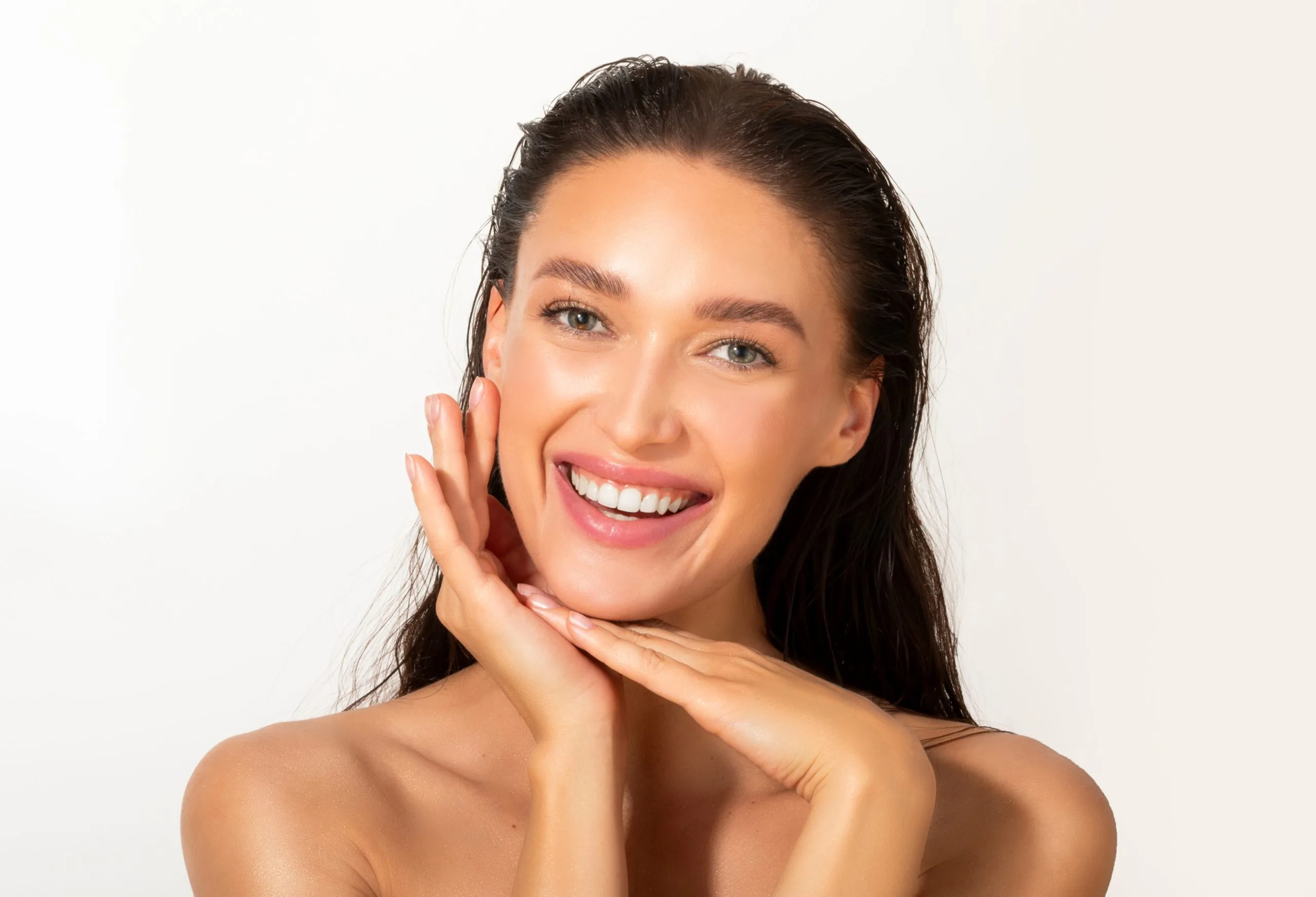 Woman smiling with hands touching her face