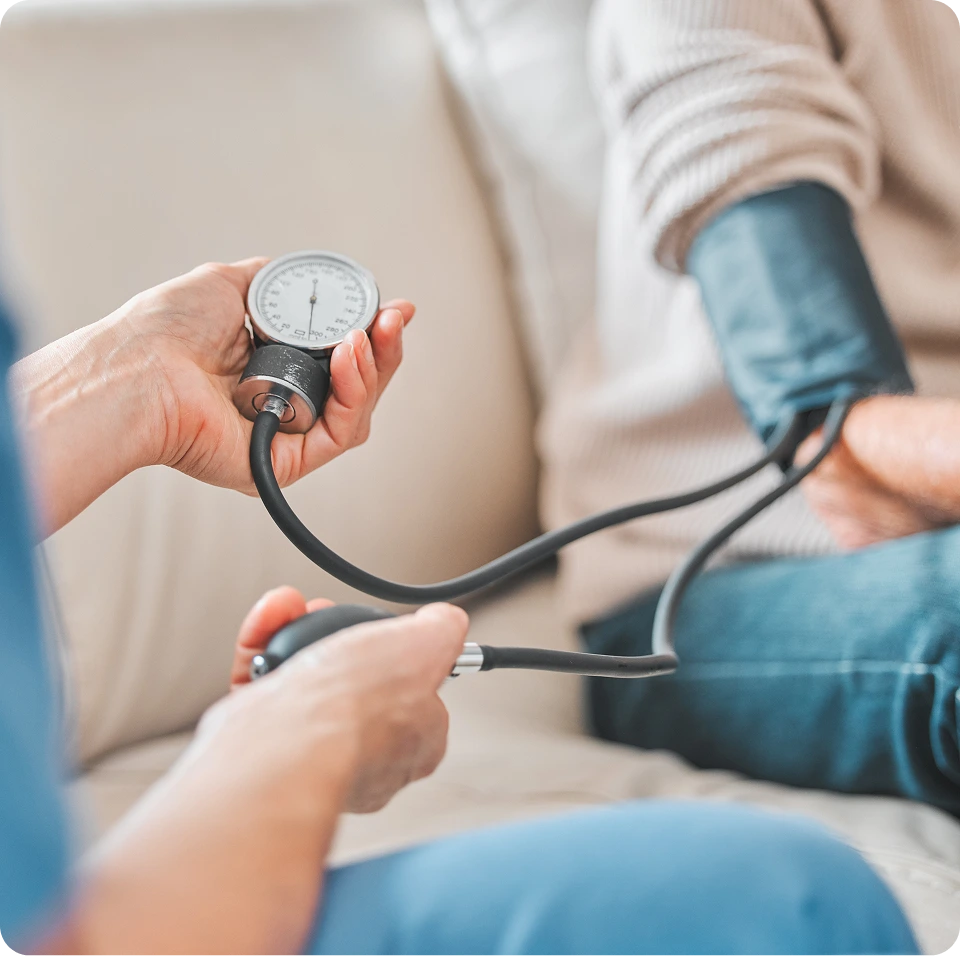 Healthcare provider checking patient's blood pressure with manual sphygmomanometer