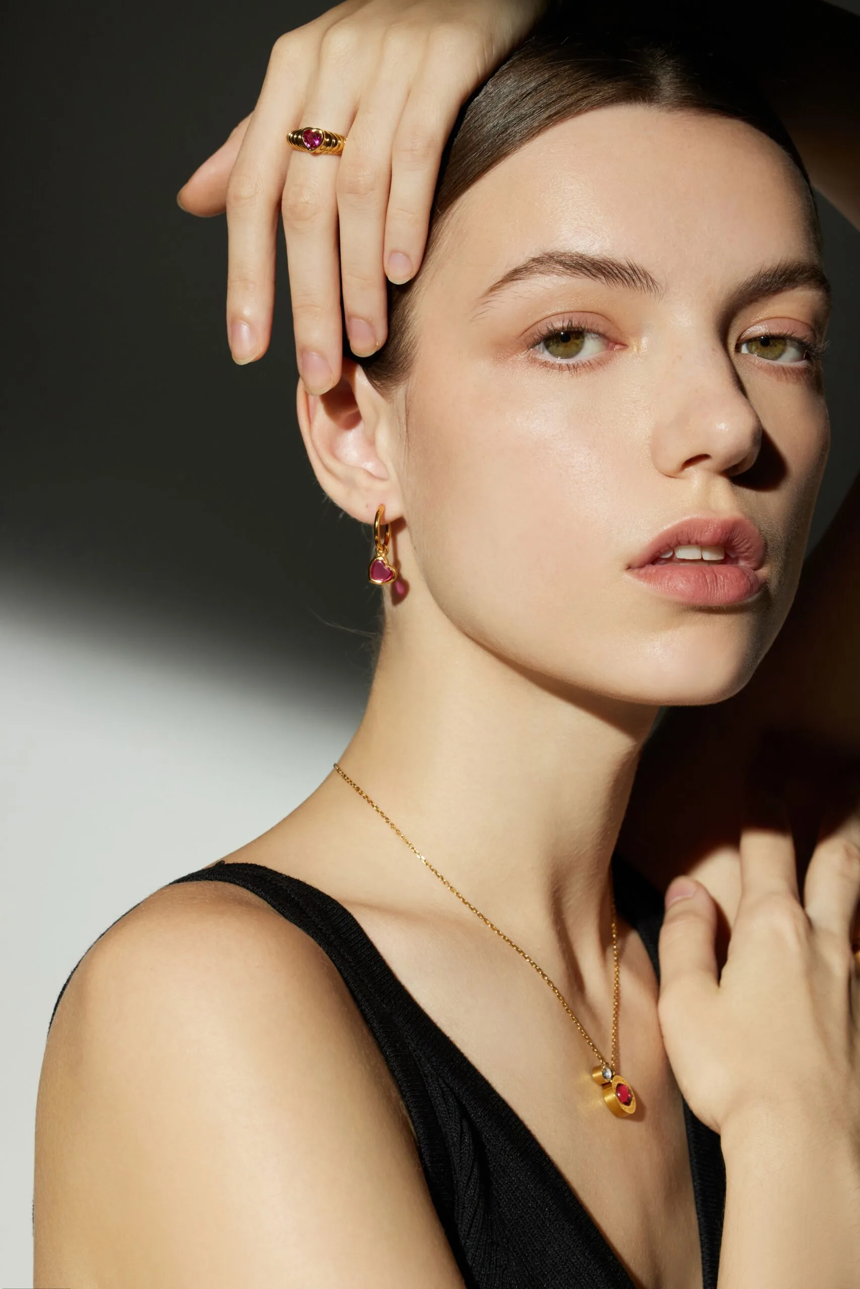 Woman with smooth, glowing skin and refined facial features touching her face