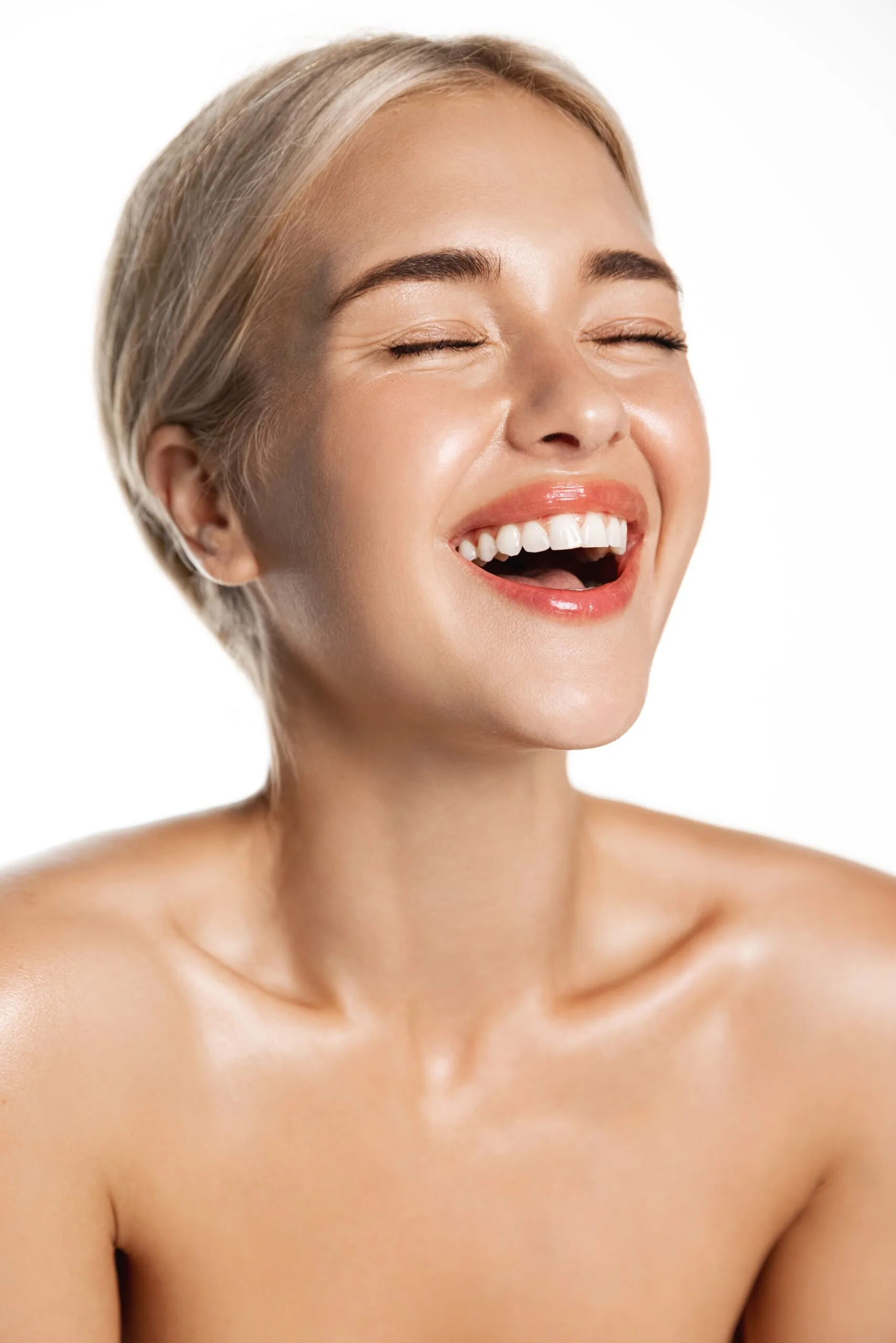 Woman with glowing skin and bright smile after GLO2 facial treatment