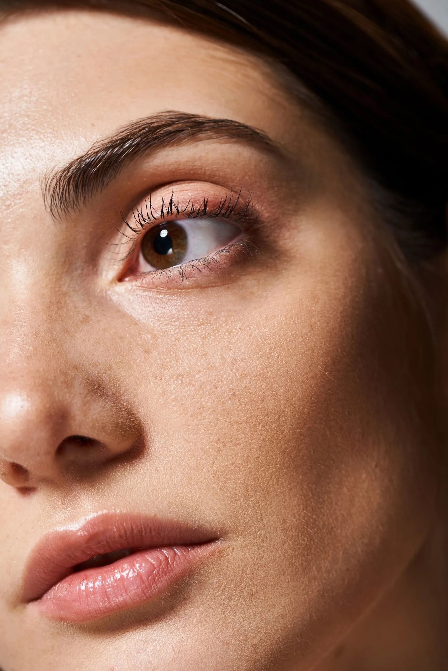 Close-up of a woman's face showing smooth, glowing skin around the eye and cheek area