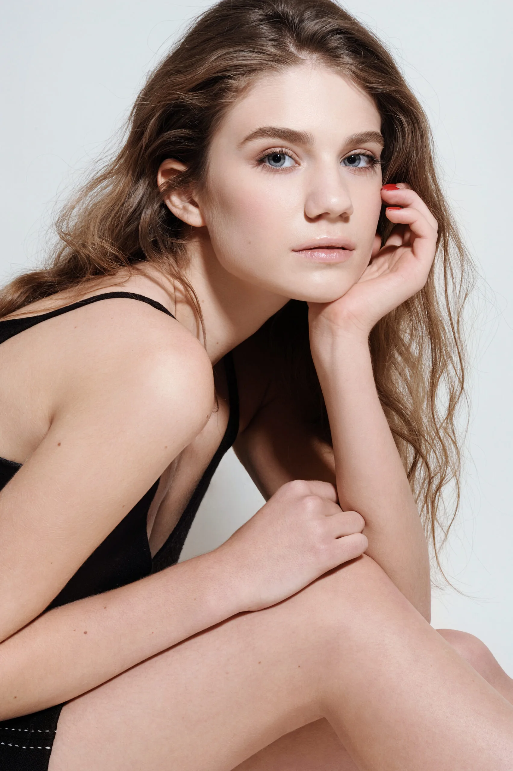Woman with clear skin posing against a neutral background