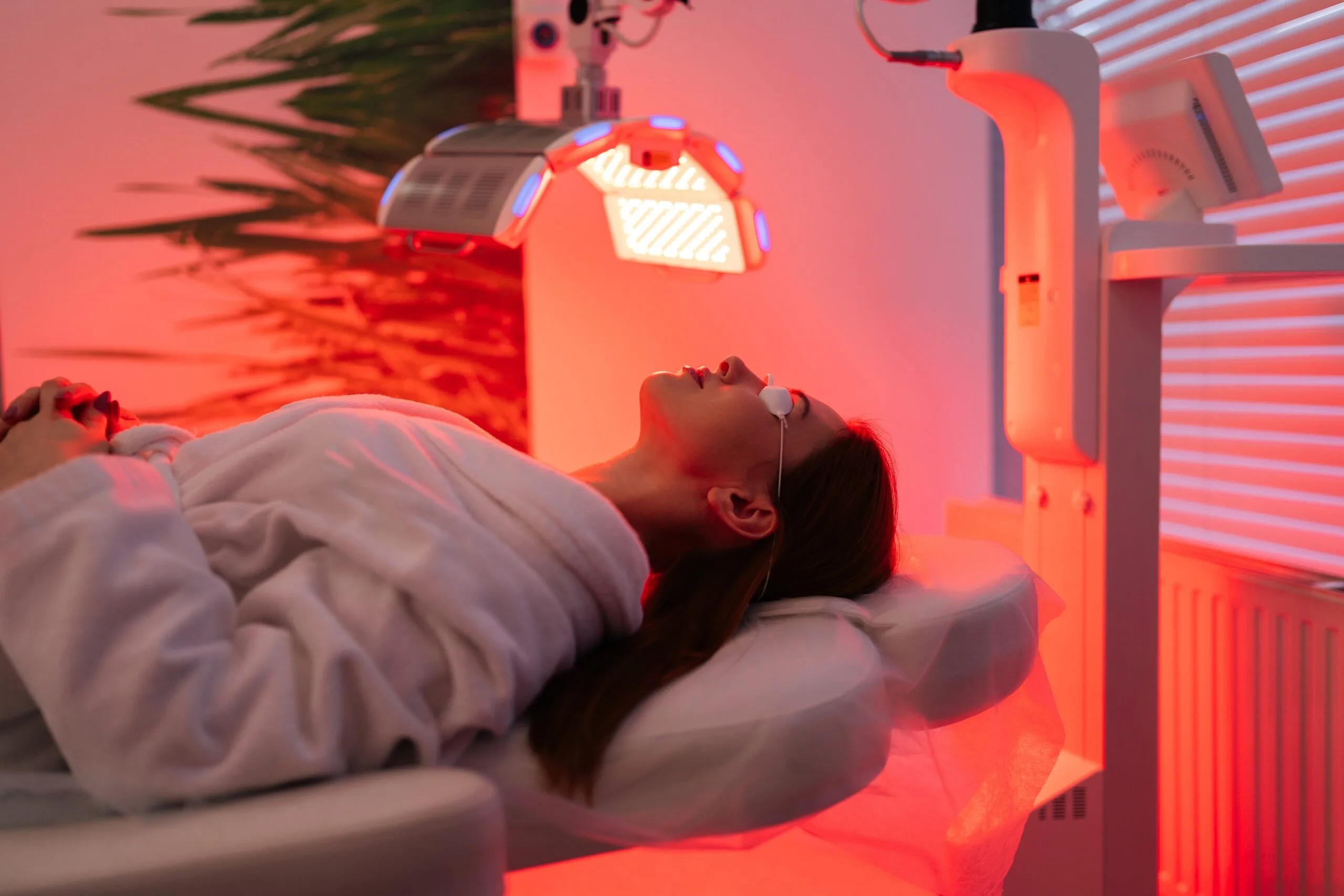 Patient receiving photodynamic therapy treatment under red and blue light panels